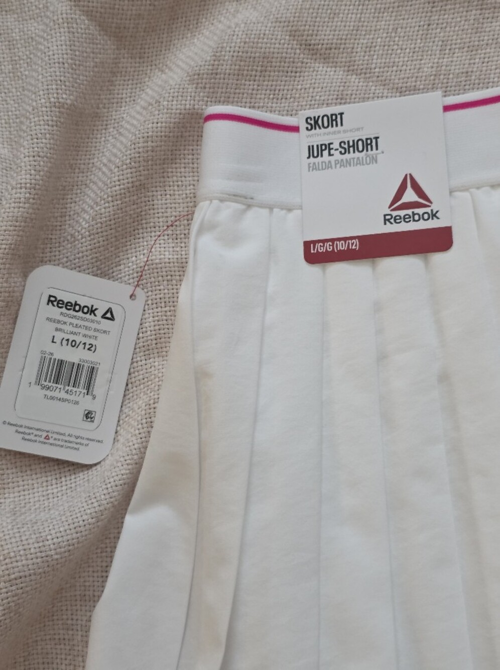 Reebok white tennis skirt features a classic pleated design with a pink accent - Picture 4 of 8
